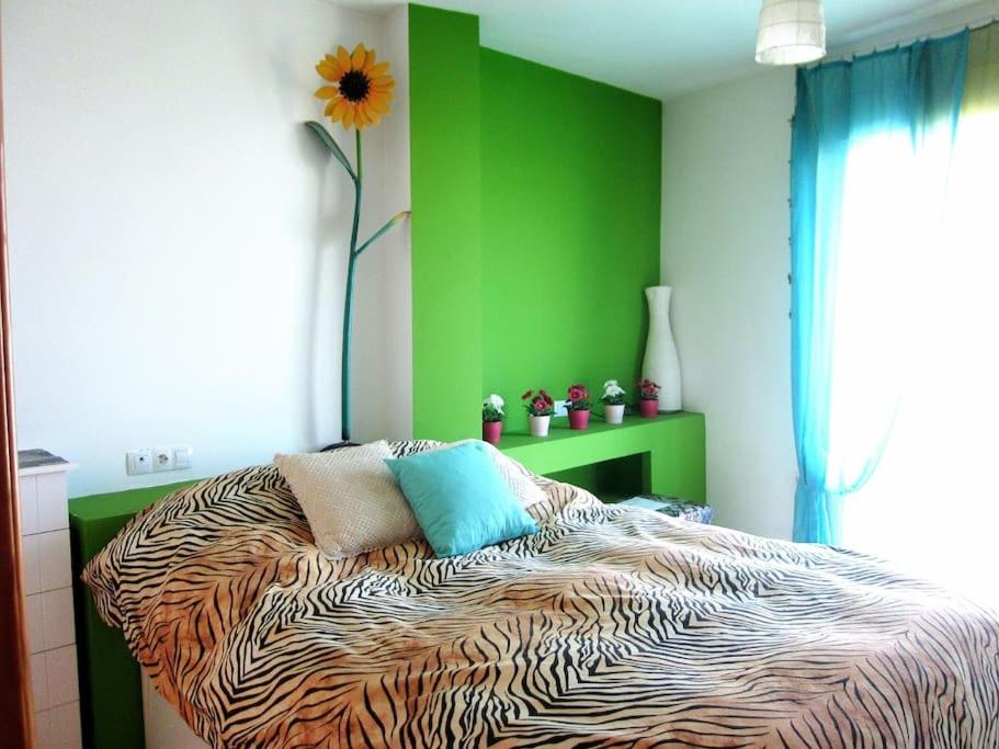 a bedroom with a bed with a green wall at THE RED TERRACE PENTHOUSE A 7Km CITY CENTER GRANADA in Churriana de la Vega