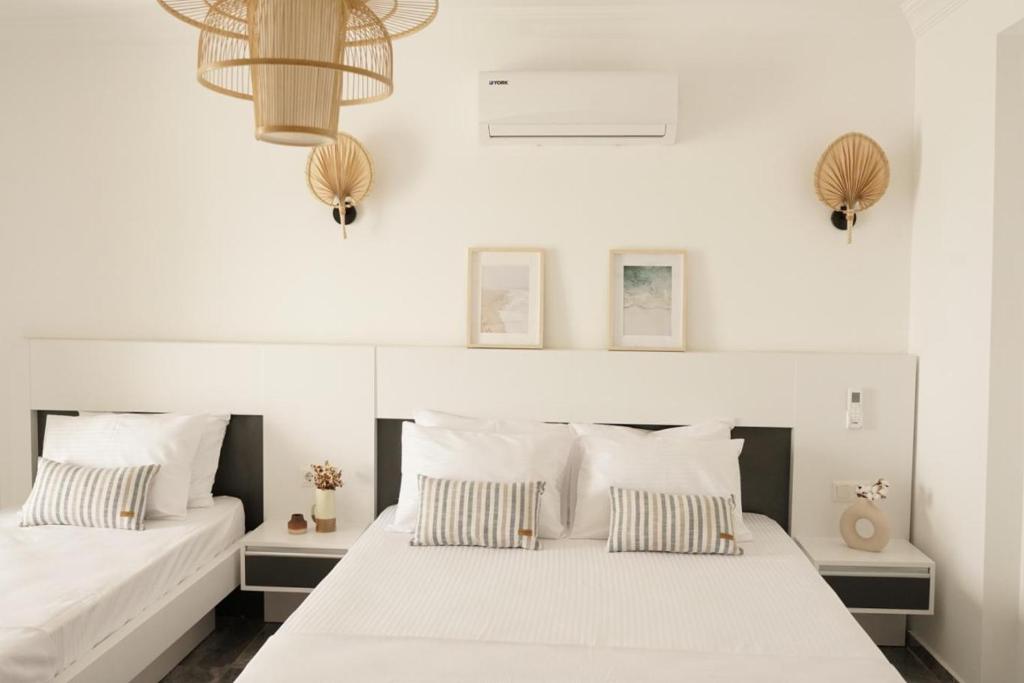 2 Betten in einem Schlafzimmer mit weißen Wänden in der Unterkunft Blue Island Luxury Hotel Adults Only in Kaş