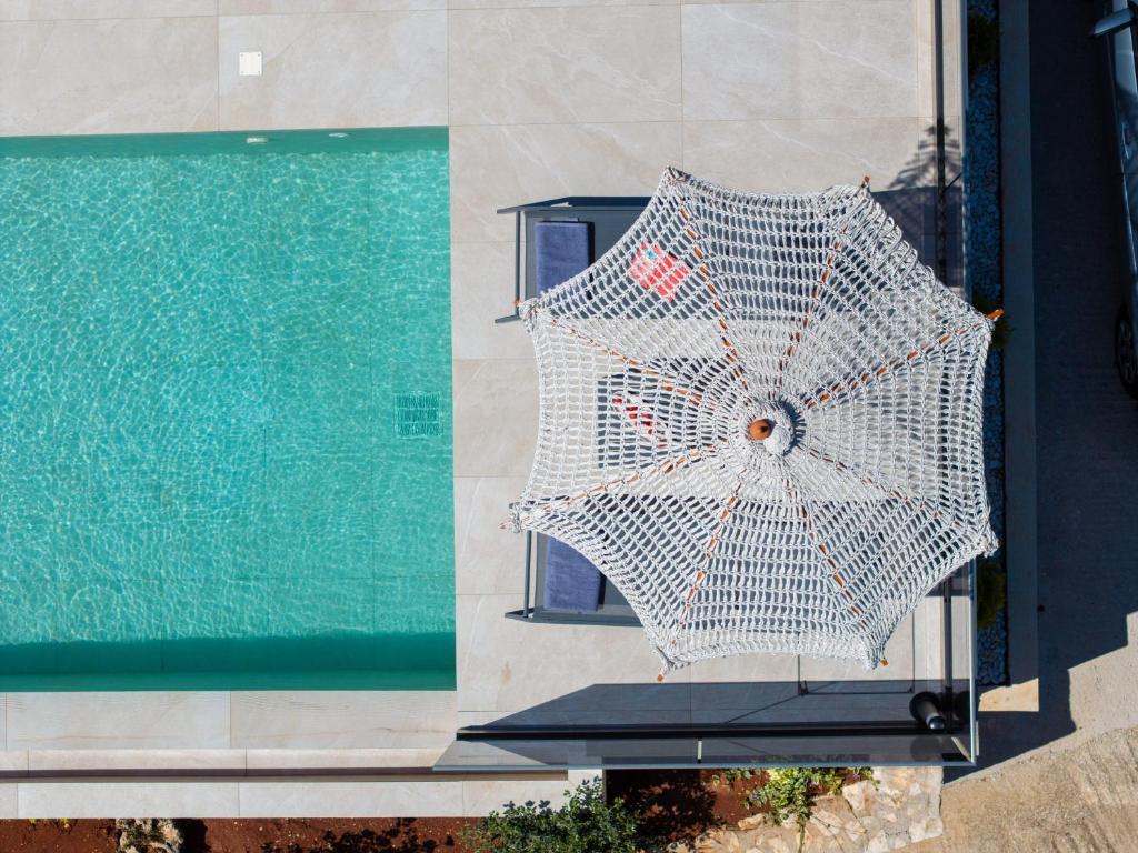 an overhead view of an umbrella next to a swimming pool at Villa Fernando - F&A Golden Stone Villas in Loukáta