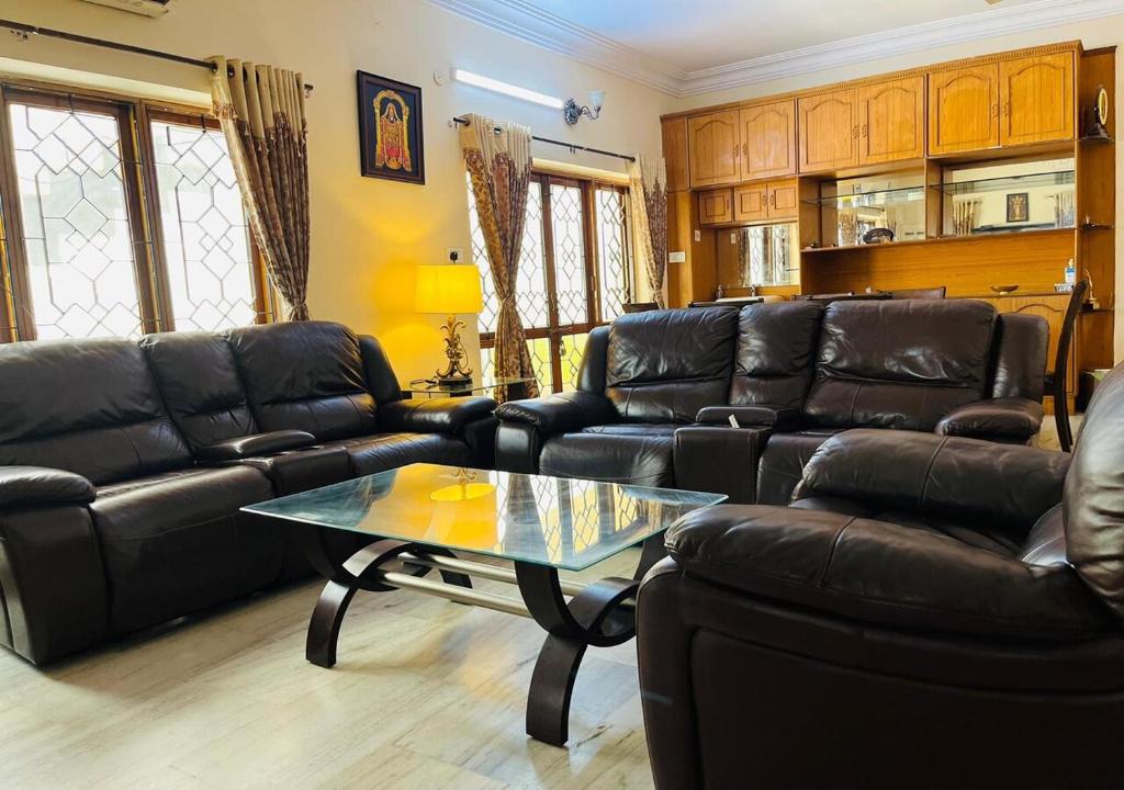 a living room with leather couches and a coffee table at Best Individual Home stay Near Apollo Jubilee Hills in Hyderabad