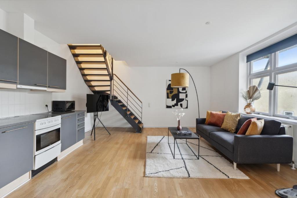 a living room with a couch and a staircase at Come Stay 2BR -Luxury Apartment 300 m from Magasin in Aarhus