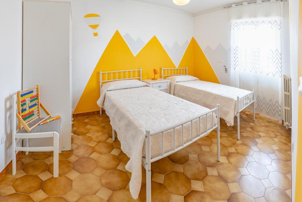 a bedroom with two beds and a mural on the wall at Appartamento Solatio con 3 camere a Presicce in Presicce