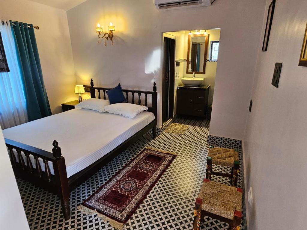 a bedroom with a large bed and a bathroom at SHANTINIKETAN RETREAT, BOLPUR in Shānti Niketan