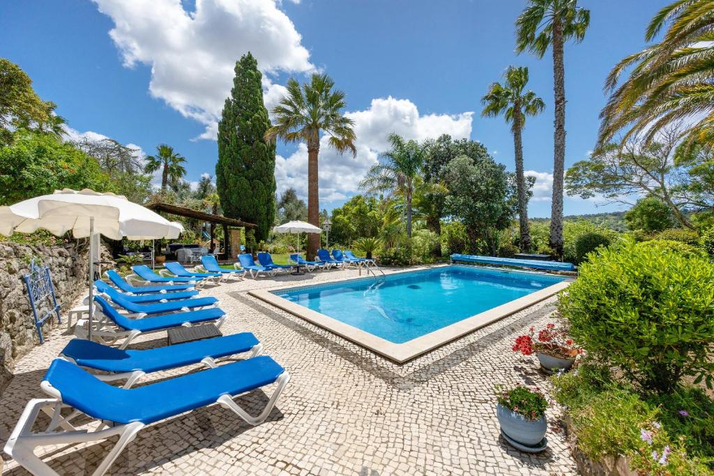 a swimming pool with lounge chairs and a swimming poolvisorvisor at Quinta das Achadas - Jasmine in Lagos