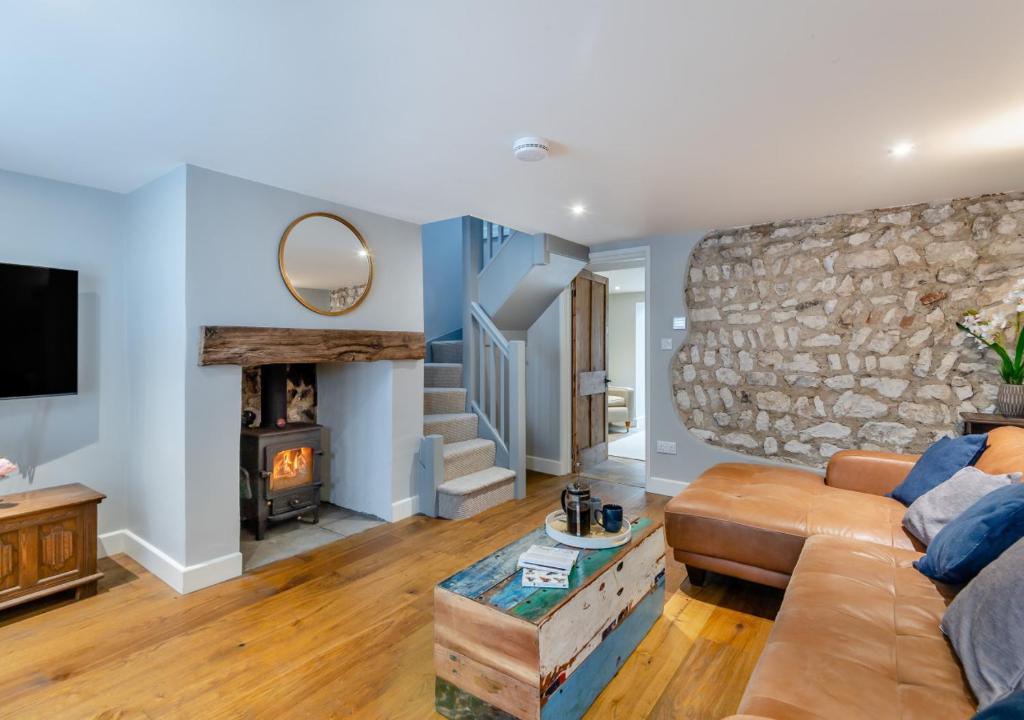 uma sala de estar com um sofá e uma parede de pedra em Fern Lea em Brancaster