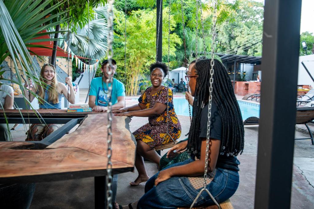 un grupo de personas sentadas en una mesa en Victoria Falls Backpackers Zambia en Livingstone
