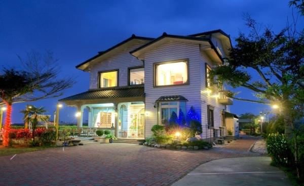 a large house with lights on in a driveway at Chun Feng Cao Tang Homestay in Yuanshan