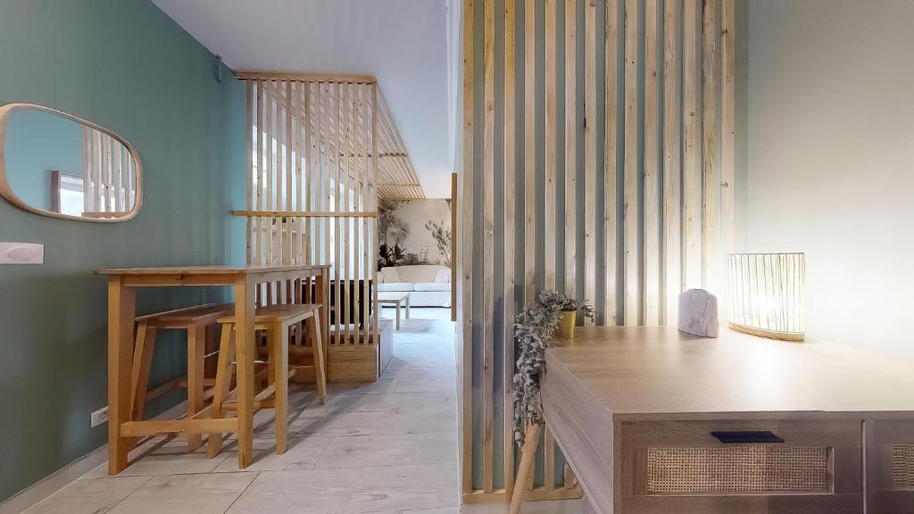 un salon avec une table et un escalier dans l'établissement Le Vert Neuilly - 10mn Paris, à Clichy