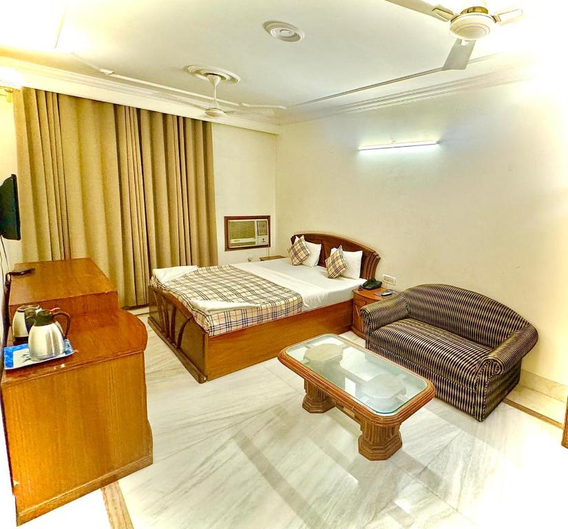 a hotel room with a bed and a couch at Hotel Pablas International, New Delhi, Near Metro in New Delhi