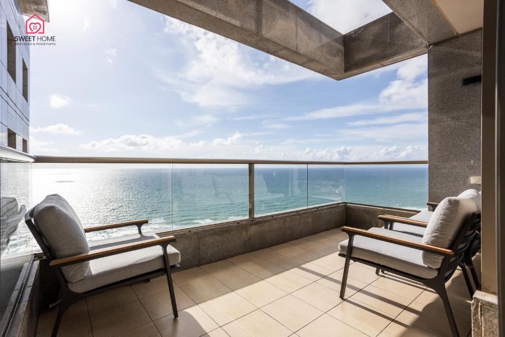 uma varanda com 2 cadeiras e vista para o oceano em Luxury apartments' in Netanya em Netanya