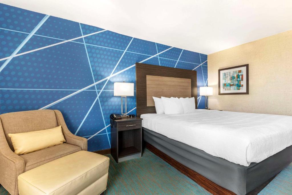 um quarto de hotel com uma cama e uma cadeira em Comfort Inn Dallas North Love Field Airport em Dallas