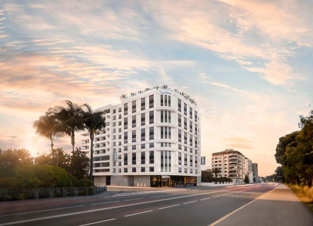 a white building on the side of a road at Radisson Hotel Casablanca Gauthier La Citadelle in Casablanca