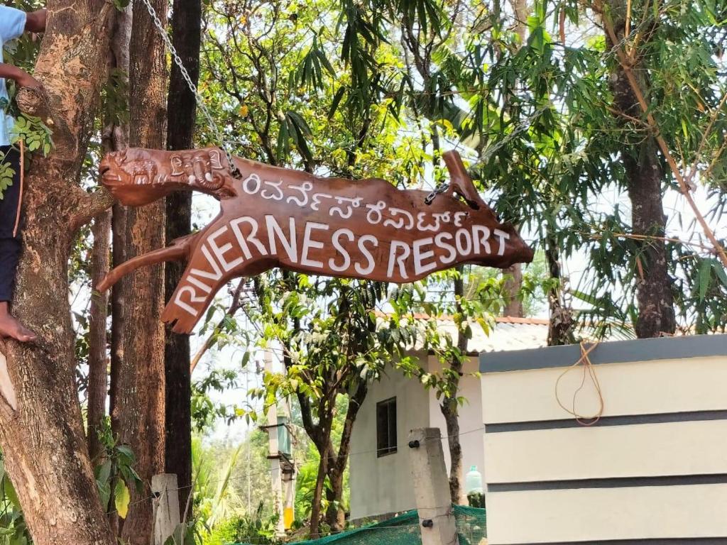 una señal para un centro de bienestar colgando de un árbol en Coorg Riverness Resort, en Kushālnagar