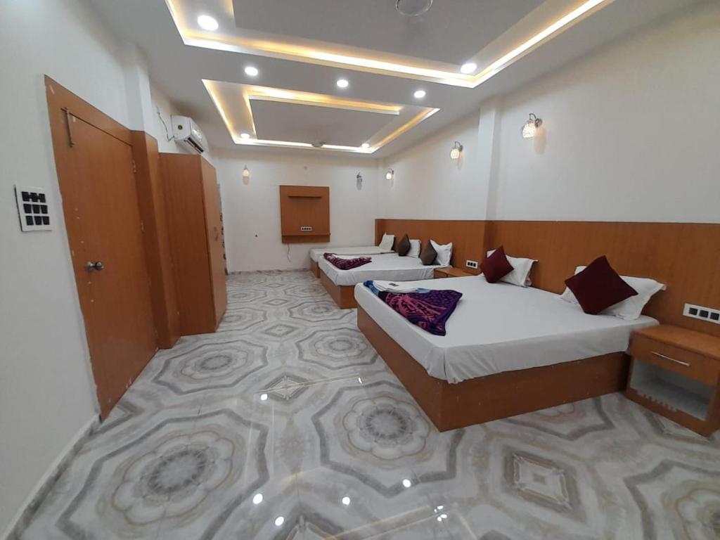 Ayodhya的住宿－Goroomgo Hotel The Nirmala Palace Ayodhya-Near Ram Mandir，一间酒店客房,设有两张床和走廊