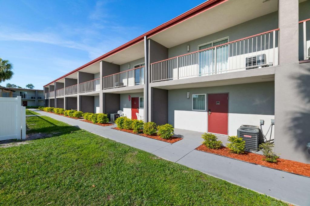 an exterior view of an apartment building with red doors at Quality Suites Wildwood - The Villages in Wildwood