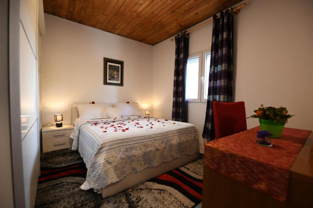 Schlafzimmer mit einem Bett, einem Tisch und einem Fenster in der Unterkunft Holliday House Marko in Hrvace