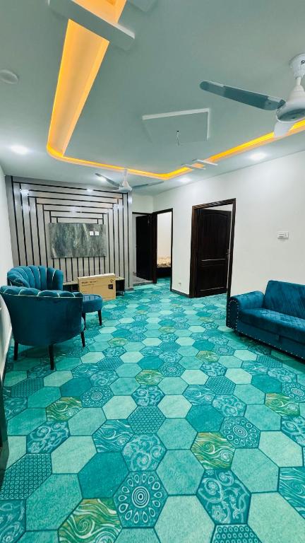 um quarto amplo com piso em azulejo e sofás em Rahat villas Apartment zing em Islamabad