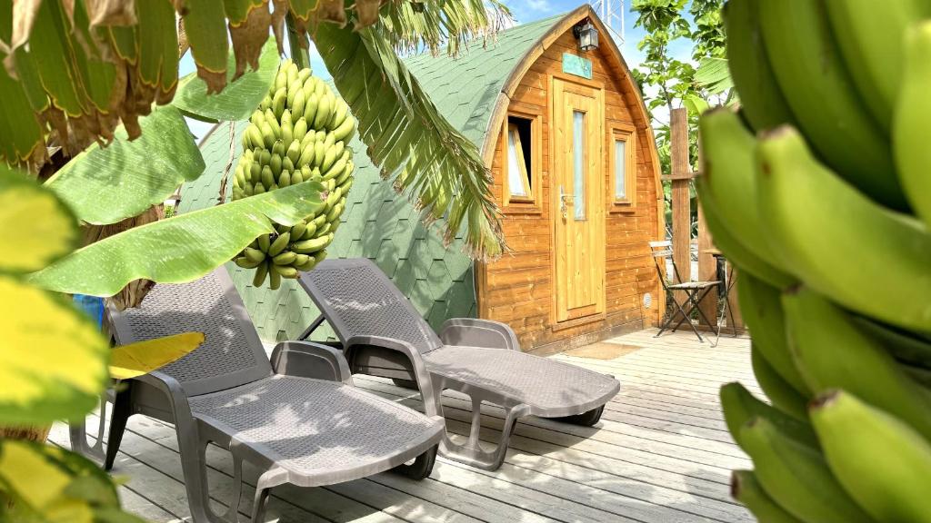 a group of chairs sitting on a deck with bananas at Lykke SUITE SPA SAUNA PISCINA Y JARDIN in Buzanada
