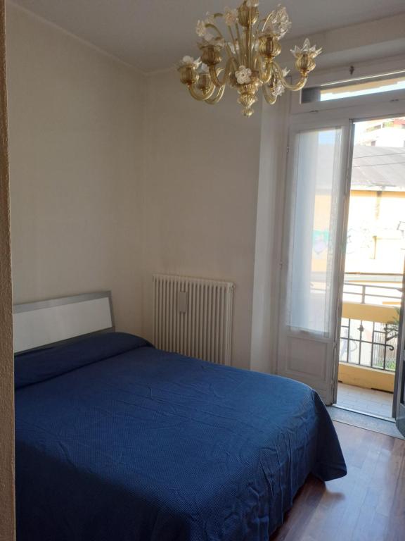 Un dormitorio con una cama azul y una lámpara de araña. en Appartamento Via Comune Antico, en Milán