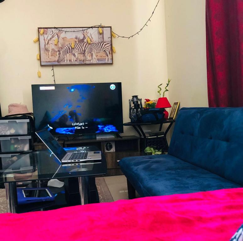 - un salon avec un canapé et une télévision grand écran dans l'établissement Premium Furnished studio, à Charjah