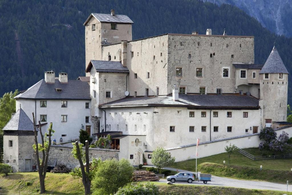 een groot kasteel met een auto voor de deur bij Schloss Naudersberg Wohnung 1 in Nauders