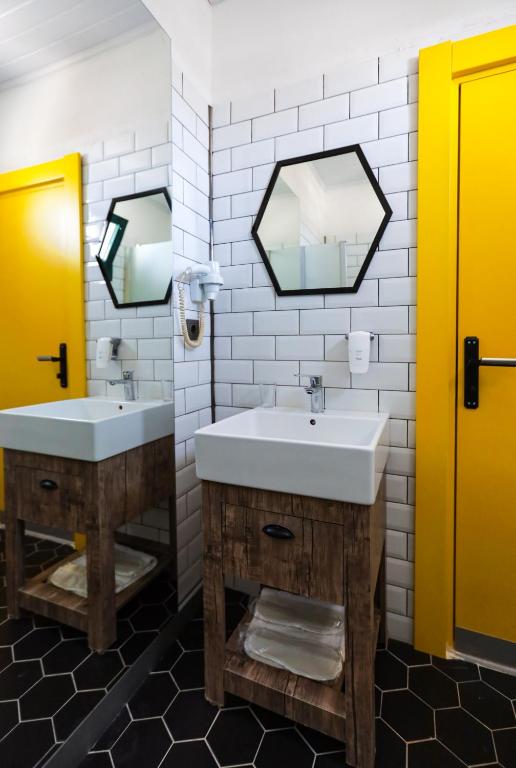 a bathroom with two sinks and two mirrors at Limon Inn Hotel, Taşucu in Tasucu