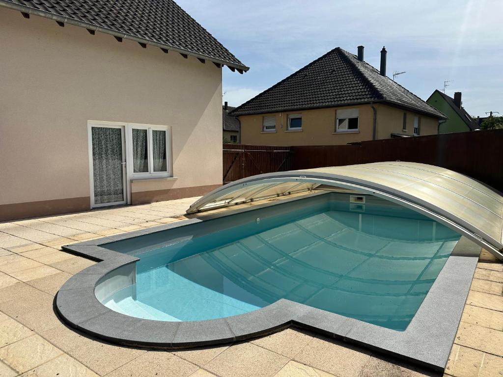 uma piscina num quintal ao lado de uma casa em Le DaubenLand em Daubensand