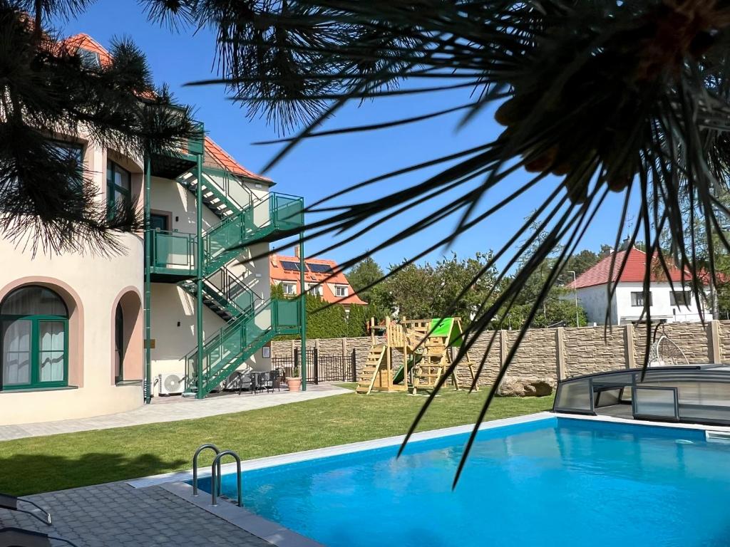 a house with a swimming pool and a playground at Residence Barrique Valtice in Valtice