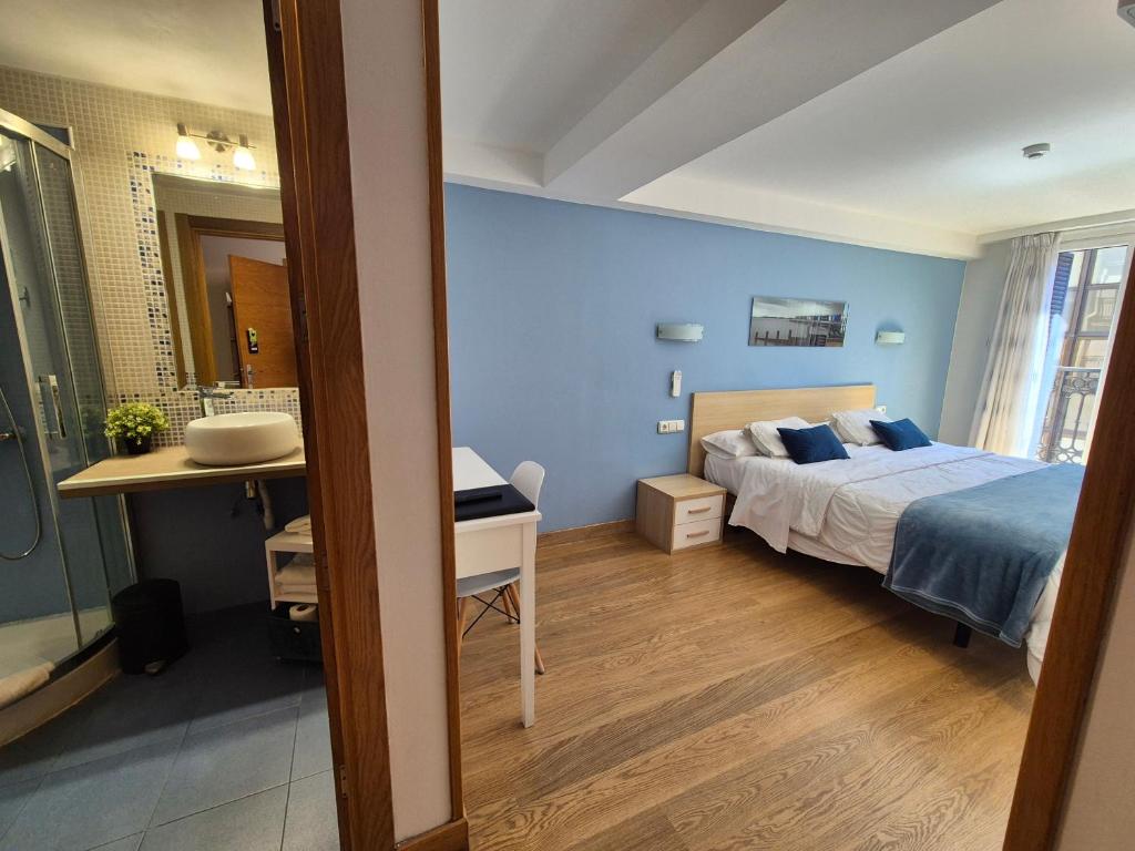 1 dormitorio con 1 cama y baño con lavamanos en Pension Joakina, en San Sebastián