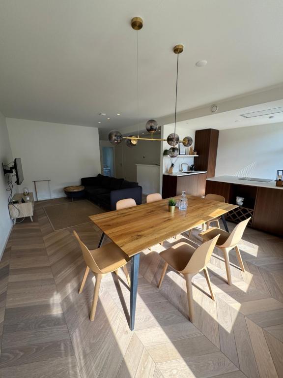 een woonkamer met een houten tafel en stoelen bij Old South - Luxury Apartment in Amsterdam