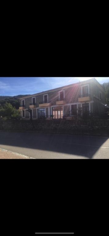 deux photos d'une maison avec un bâtiment dans l'établissement Hotel Les Calanques, à Piana