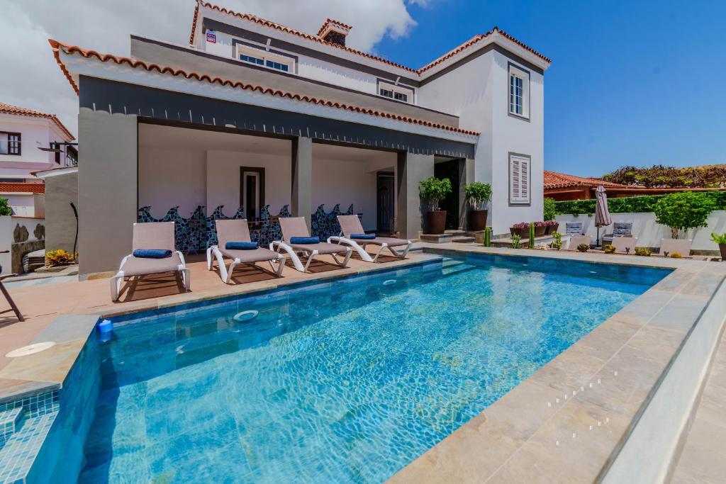 a villa with a swimming pool and a house at Villa in south of Tenerife in Arona