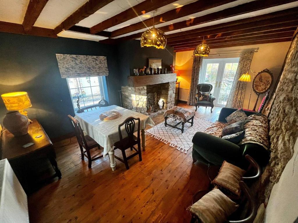 een woonkamer met een tafel en een bank bij 17th century cottage on farm in Vale of Glamorgan in Bonvilston
