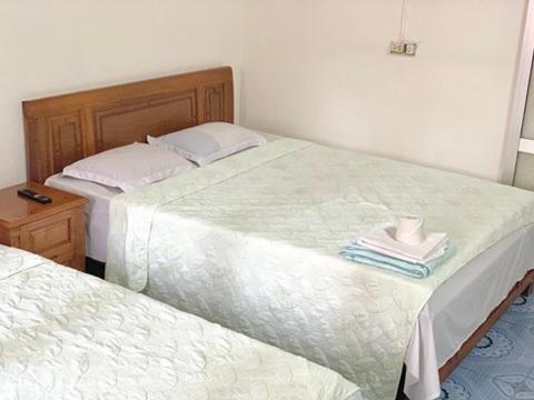 two twin beds in a bedroom with a table at Friendly room in Hai Phong