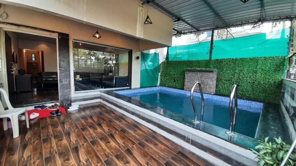 een zwembad in het midden van een huis bij Ivy Tungarli Dream Villa (4 BHK - Indoor Pool), Lonavala in Lonavala