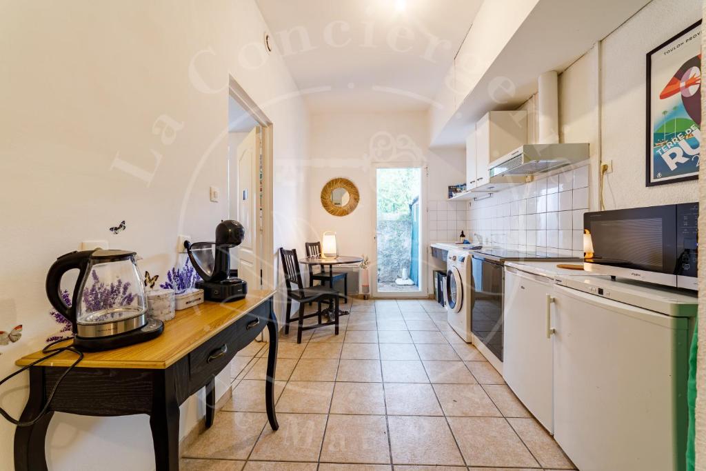 une cuisine avec un comptoir et une table dans l'établissement Le Voltaire - Escapade ensoleillée avec terrasse, à Toulon