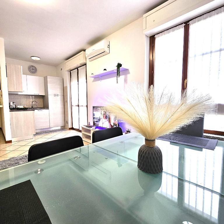 ein Wohnzimmer mit einem Glastisch mit einer Vase darauf in der Unterkunft Appartamento Moderno Gallarate in Gallarate