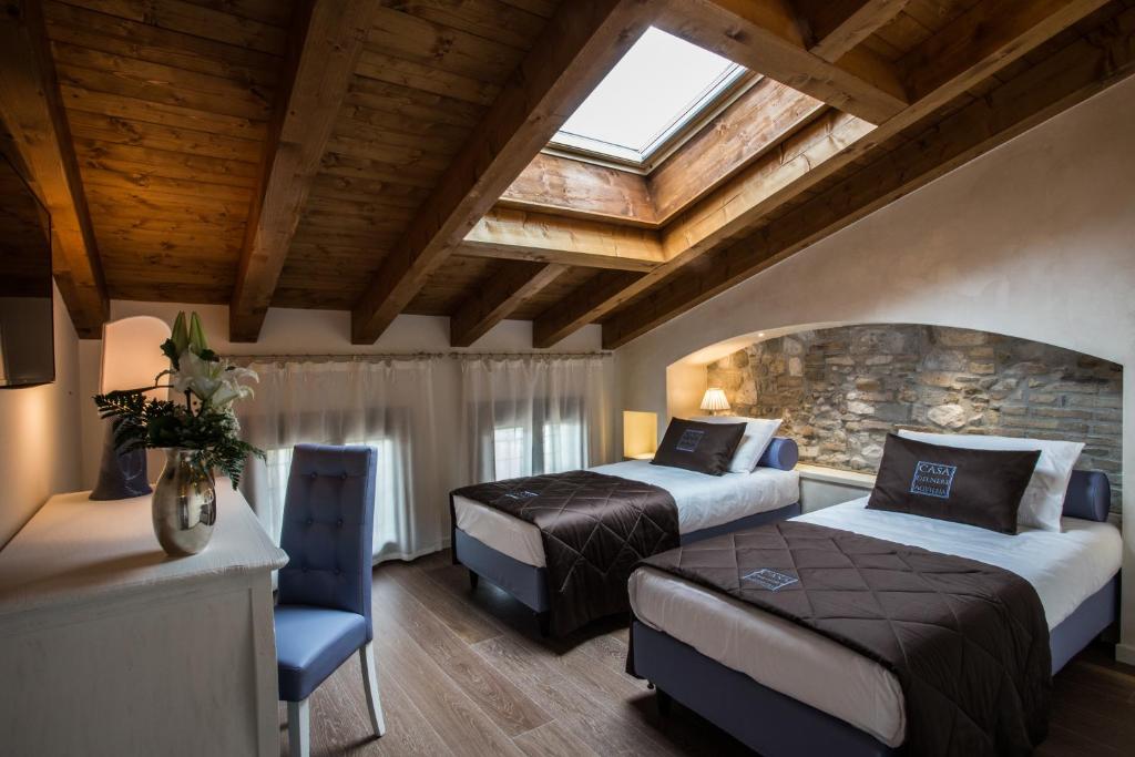 a hotel room with two beds and a window at Casa Delneri Aquileia Adults Only in Aquiléia
