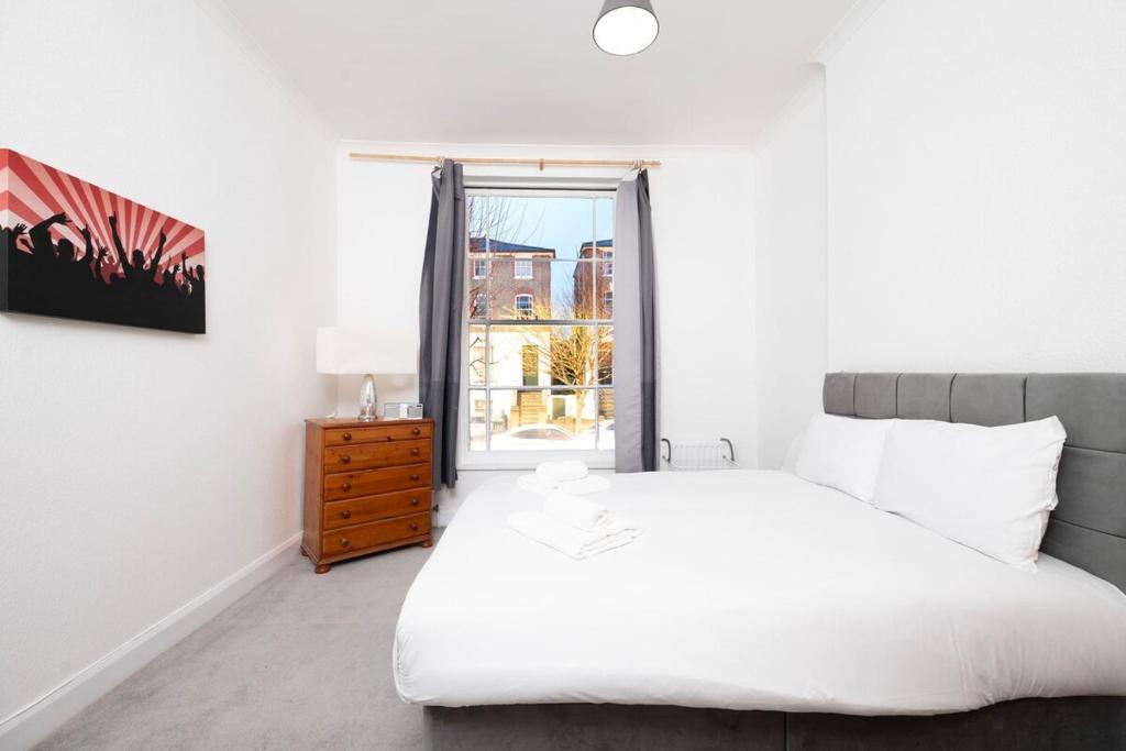 a bedroom with a white bed and a window at Spacious minimalist 1BR flat in London in London