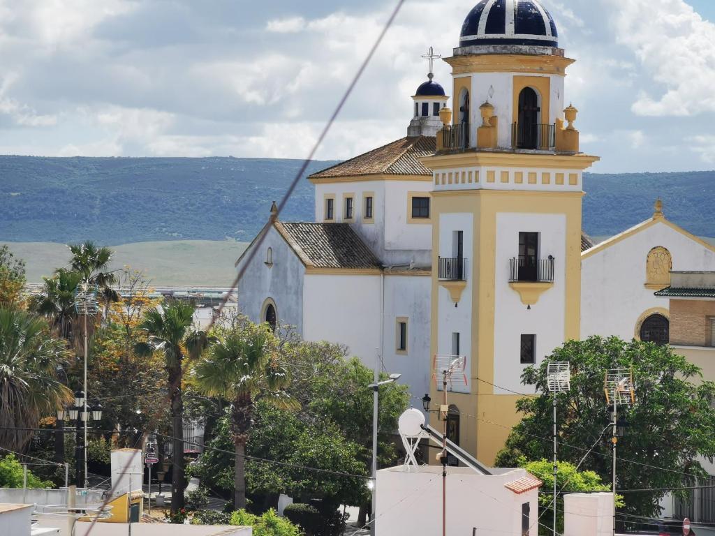 un edificio amarillo y blanco con una torre de reloj en Casa Castillo de Santiago Barbate, en Barbate