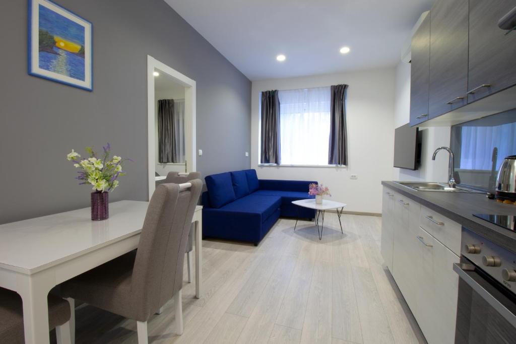 een keuken en een woonkamer met een blauwe bank bij Split Urban Getaway in Split