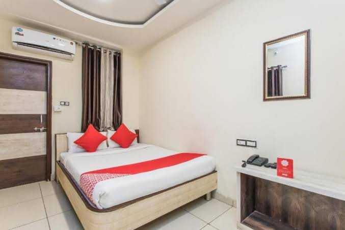 una camera da letto con un letto con cuscini rossi di Hotel Mehar Residency a Indore