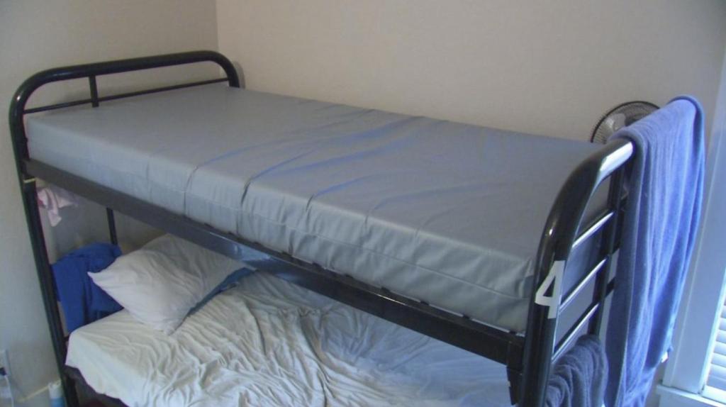 ein schwarzes Etagenbett mit blauer Matratze darauf in der Unterkunft Thomas Place in Dublin