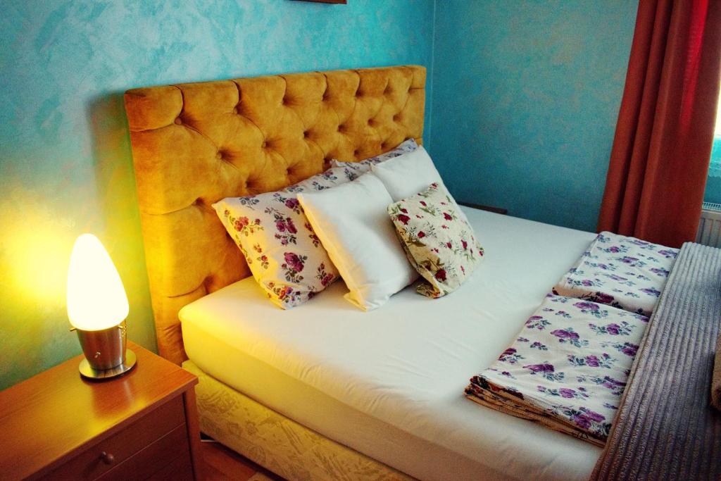 - un lit avec des oreillers et une lampe sur une table dans l'établissement Marilyn Apartments, à Smederevo