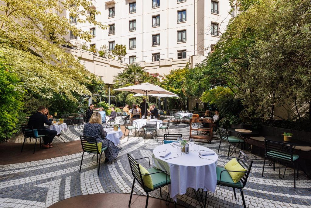 a patio with tables and chairs and a building at Novotel Paris Les Halles in Paris