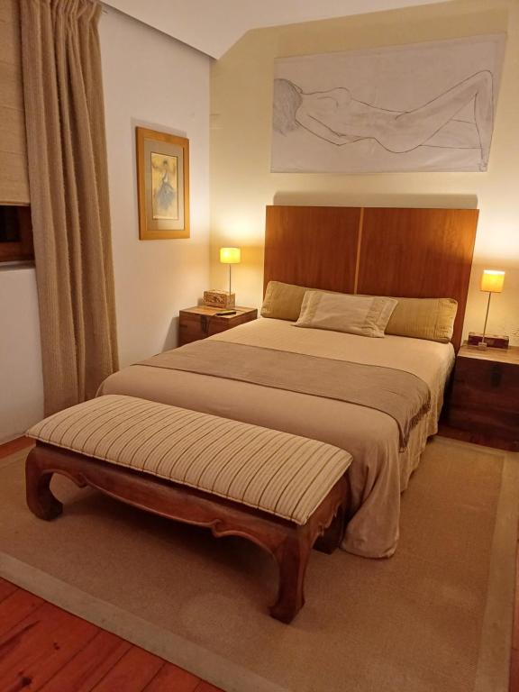 um quarto com uma cama grande e uma cabeceira em madeira em Casa Mali em Quinta do Conde