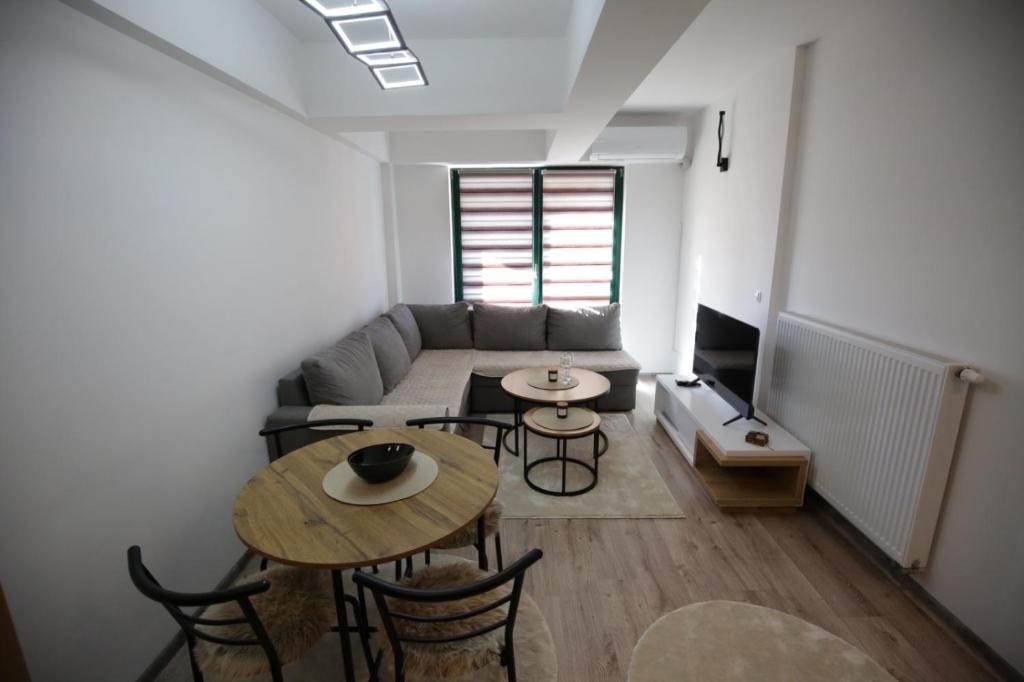 a living room with a couch and a table and chairs at Apartman Hana Fojnica in Fojnica