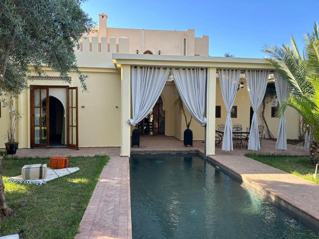 a house with a swimming pool in front of it at Palais Ines in Marrakesh