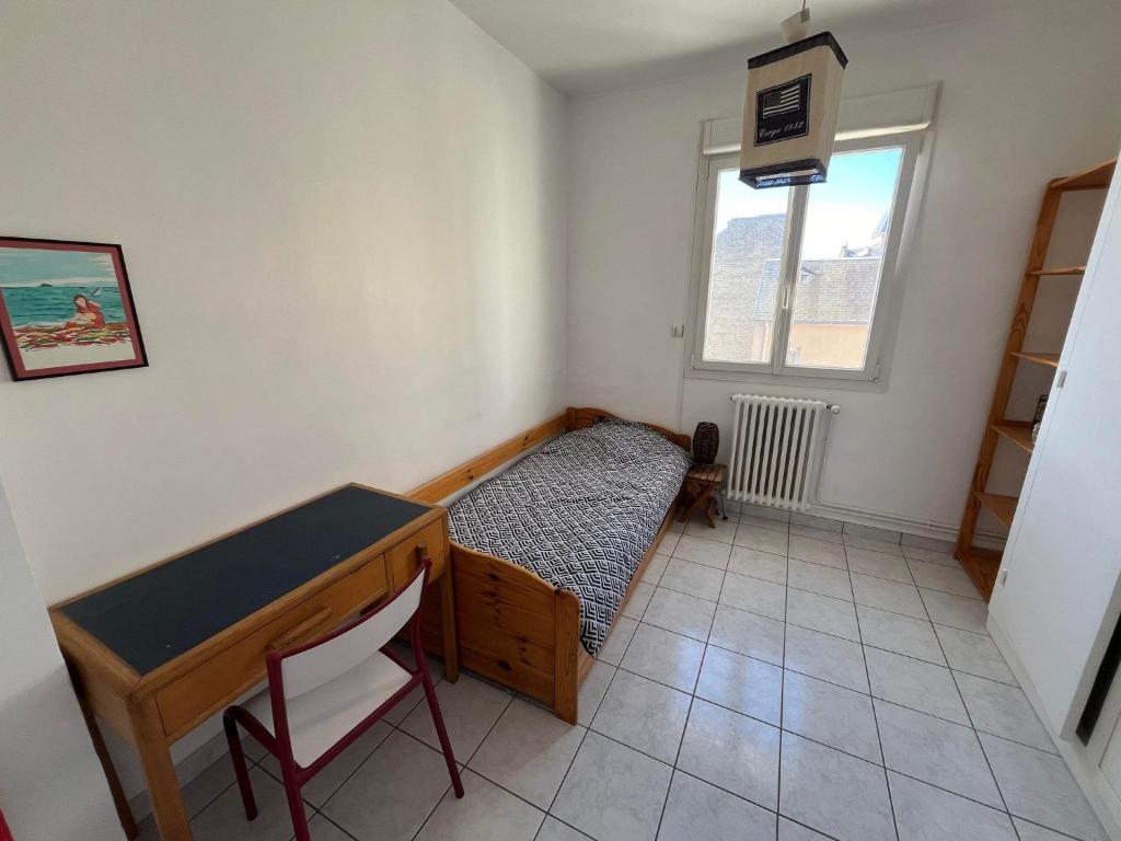 ein Schlafzimmer mit Bett, Schreibtisch und Fenster in der Unterkunft Chambre entre plage et centre ville dans maison avec jardin in Le Havre