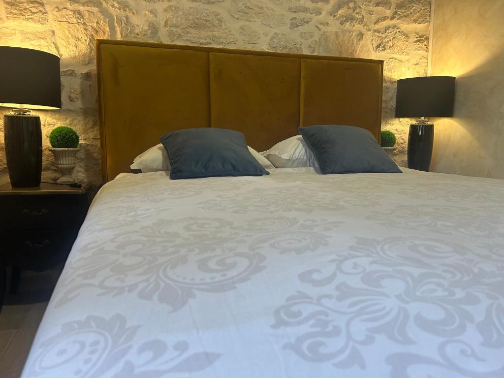 sypialnia z dużym łóżkiem z 2 niebieskimi poduszkami w obiekcie Stone house Chiara Seaview w mieście Funtana